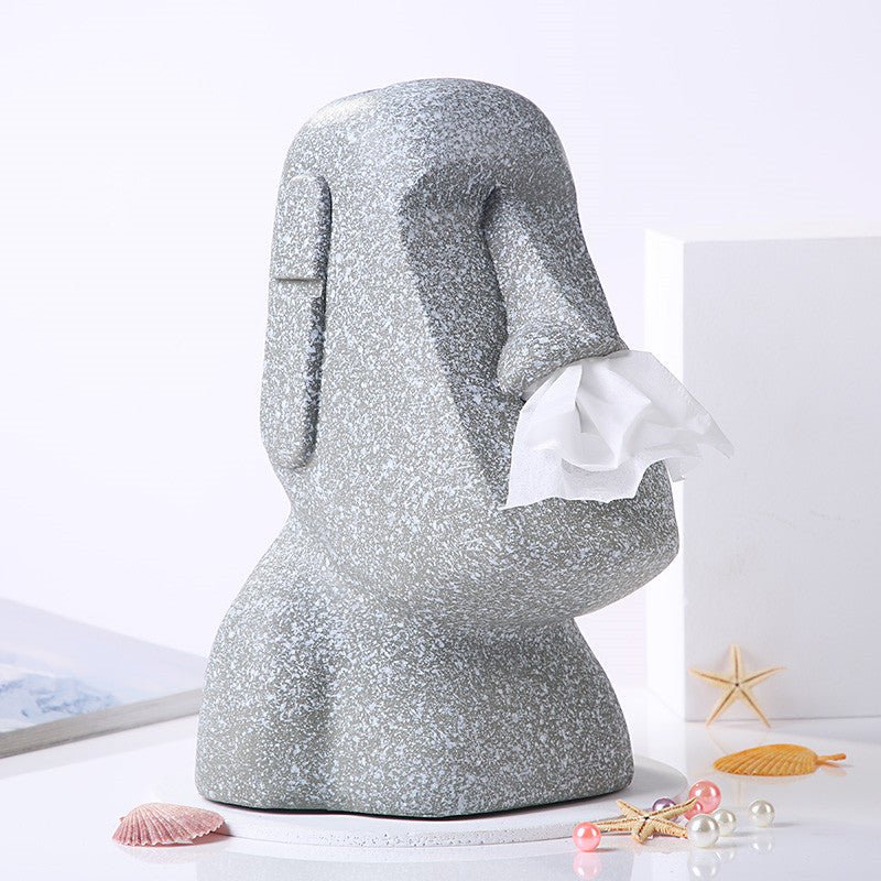 Side view of grey Moai tissue box holder with tissue dispensing from the nose