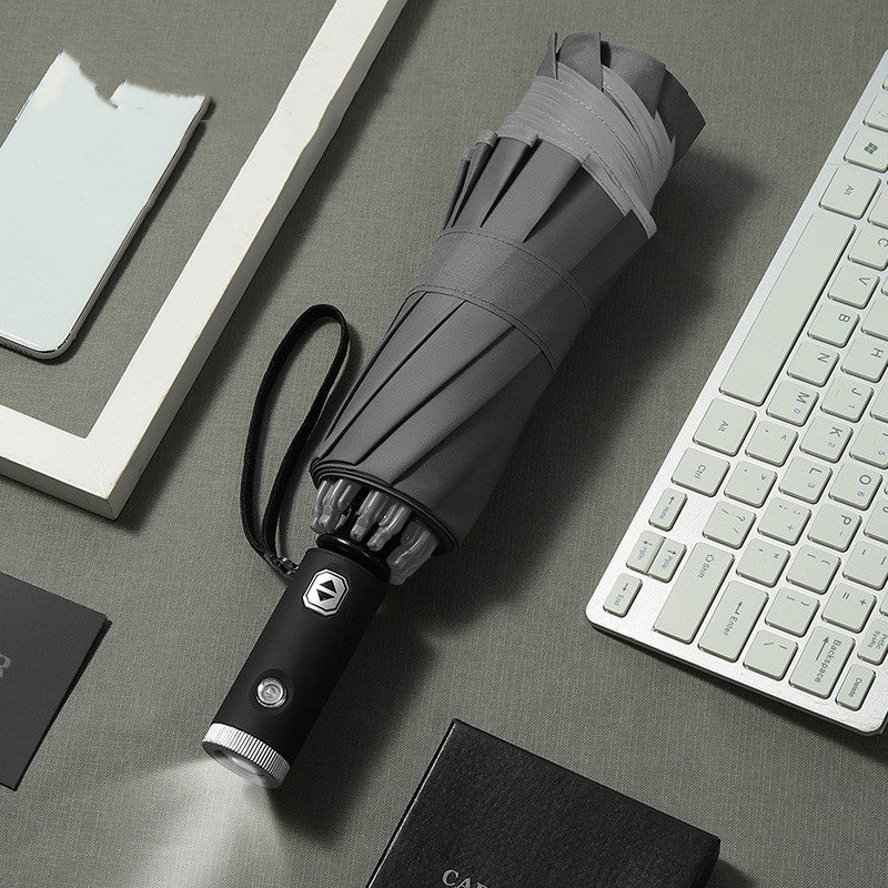 Reverse Umbrella with Reflective Safety Strip and Torch grey on table with keyboard